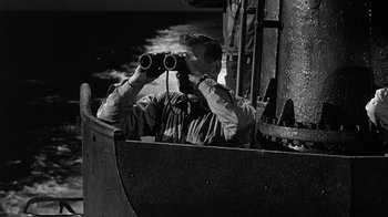 Movie still from “Run Silent Run Deep” (1958), directed by Robert Wise – A black and white photo of a man looking through binoculars on a boat; Medium shot, High angle