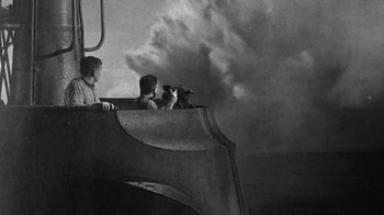 Movie still from “Run Silent Run Deep” (1958), directed by Robert Wise – Two men are on a boat looking out at the sky; Medium shot, Low angle