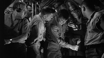 Movie still from “Run Silent Run Deep” (1958), directed by Robert Wise – A group of men standing next to each other in a room; Medium shot, Low angle
