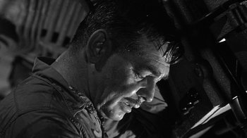 Movie still from “Run Silent Run Deep” (1958), directed by Robert Wise – Black and white photograph of a man with wet hair; Close Up shot, Low angle