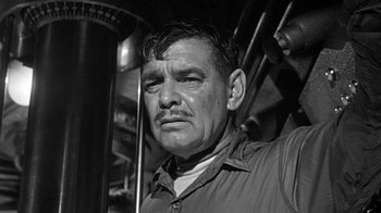 Movie still from “Run Silent Run Deep” (1958), directed by Robert Wise – An older man with a beard and mustache in front of pipes; Close Up shot, Low angle