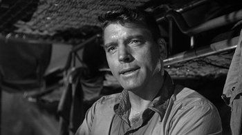 Movie still from “Run Silent Run Deep” (1958), directed by Robert Wise – Black and white photograph of a man in front of an umbrella; Close Up shot, Low angle