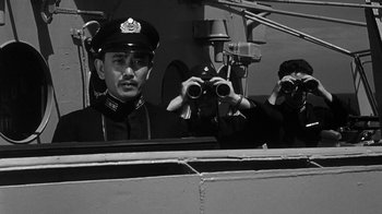 Movie still from “Run Silent Run Deep” (1958), directed by Robert Wise – A man wearing a uniform and a hat is looking through binoculars on a boat; Medium shot, Low angle