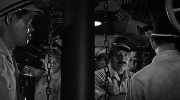 Movie still from “Run Silent Run Deep” (1958), directed by Robert Wise – Black and white photograph of a group of men in uniform; Medium shot, Low angle