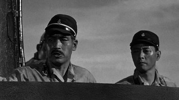 Movie still from “Run Silent Run Deep” (1958), directed by Robert Wise – A black and white photo of two men in military uniforms; Close Up shot, Low angle