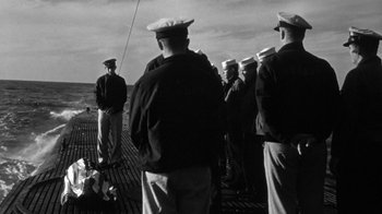 Movie still from “Run Silent Run Deep” (1958), directed by Robert Wise – A black and white photo of a group of men on a boat; Wide shot, Over the shoulder angle