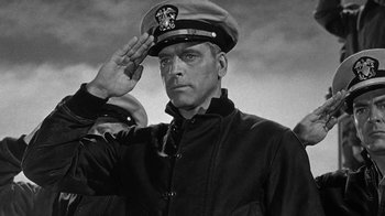 Movie still from “Run Silent Run Deep” (1958), directed by Robert Wise – A man saluting while wearing a hat; Medium shot, Low angle