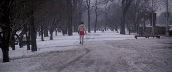 Movie still from “Running Scared” (1986), directed by Peter Hyams – A woman in a red skirt walking in the snow; Wide shot, Low angle