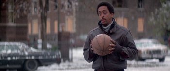 Movie still from “Running Scared” (1986), directed by Peter Hyams – A man holding a basketball in his hands; Medium shot, Low angle