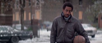Movie still from “Running Scared” (1986), directed by Peter Hyams – A man wearing a leather jacket walking in the snow; Close Up shot, Low angle
