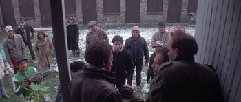 Movie still from “Running Scared” (1986), directed by Peter Hyams – A group of people standing around in the snow; Wide shot, High angle