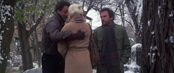 Movie still from “Running Scared” (1986), directed by Peter Hyams – A group of people standing next to each other on the street; Medium shot, Over the shoulder angle