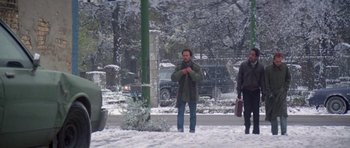 Movie still from “Running Scared” (1986), directed by Peter Hyams – A man standing in the snow with his hands in his pockets; Wide shot, Low angle