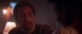 Movie still from “Running Scared” (1986), directed by Peter Hyams – A person sitting in front of another person; Close Up shot, Over the shoulder angle