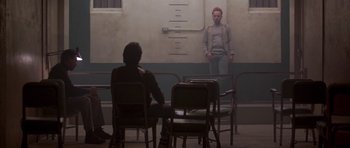 Movie still from “Running Scared” (1986), directed by Peter Hyams – Two people sitting at a table in front of a mirror; Wide shot, Low angle