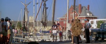 A group of people standing on a dock near a boat