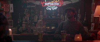 Movie still from “Running Scared” (1986), directed by Peter Hyams – A man sitting at the bar of a restaurant; Medium shot, Low angle