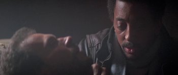 Movie still from “Running Scared” (1986), directed by Peter Hyams – A person wearing a leather jacket; Close Up shot, Over the shoulder angle