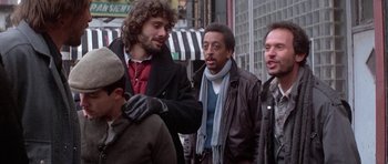 Movie still from “Running Scared” (1986), directed by Peter Hyams – A group of men standing on the sidewalk; Medium shot, Over the shoulder angle