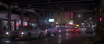 Movie still from “Running Scared” (1986), directed by Peter Hyams – Cars are lined up in traffic on a rainy night; Wide shot, Low angle
