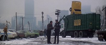 Movie still from “Running Scared” (1986), directed by Peter Hyams – Two men standing in the middle of a street; Wide shot, Low angle