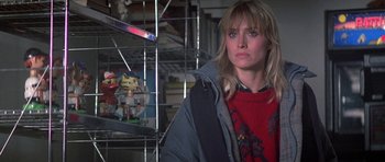 Movie still from “Running Scared” (1986), directed by Peter Hyams – A woman standing in front of a display of toys; Close Up shot, Low angle