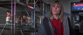 Movie still from “Running Scared” (1986), directed by Peter Hyams – A woman standing in front of a cage with toys; Close Up shot, Low angle