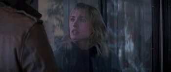 Movie still from “Running Scared” (1986), directed by Peter Hyams – A woman looking out of a window at night; Close Up shot, Over the shoulder angle