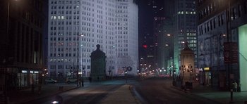 Movie still from “Running Scared” (1986), directed by Peter Hyams – A city street at night lit up by streetlights; Extreme Wide shot, High angle