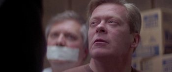 Movie still from “Running Scared” (1986), directed by Peter Hyams – Two men with their mouths taped shut; Close Up shot, Low angle