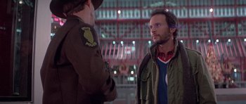 Movie still from “Running Scared” (1986), directed by Peter Hyams – Two men are standing in front of each other; Medium shot, Over the shoulder angle