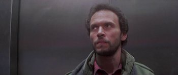 Movie still from “Running Scared” (1986), directed by Peter Hyams – A person looking up at something; Close Up shot, Low angle