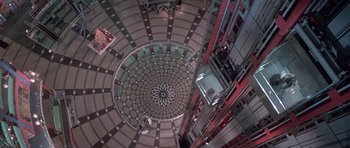 Movie still from “Running Scared” (1986), directed by Peter Hyams – Looking down at a building with a circular pattern in the center of the floor; Extreme Wide shot, Overhead angle