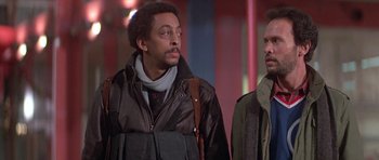 Movie still from “Running Scared” (1986), directed by Peter Hyams – Two men are standing next to each other; Close Up shot, Low angle