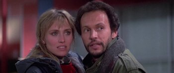 Movie still from “Running Scared” (1986), directed by Peter Hyams – A man and a woman standing next to each other; Close Up shot, Low angle