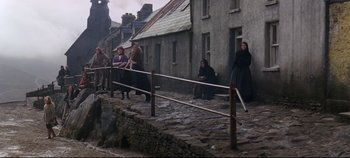 Movie still from “Ryan's Daughter” (1970), directed by David Lean – A group of people standing on a stone walkway; Wide shot, High angle