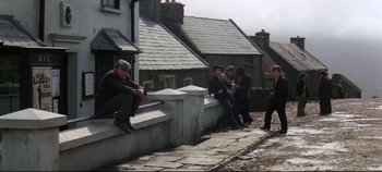 Movie still from “Ryan's Daughter” (1970), directed by David Lean – A group of people sitting on a wall; Wide shot, High angle