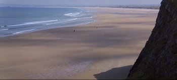 Movie still from “Ryan's Daughter” (1970), directed by David Lean – Two people walking on a beach near the ocean; Extreme Wide shot, High angle