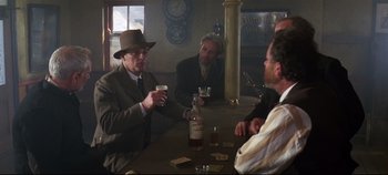 Movie still from “Ryan's Daughter” (1970), directed by David Lean – A group of men sitting at a table with drinks; Wide shot, Over the shoulder angle