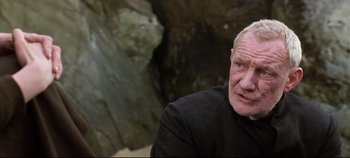 Movie still from “Ryan's Daughter” (1970), directed by David Lean – An older man wearing a black shirt is looking at the camera; Close Up shot, Over the shoulder angle