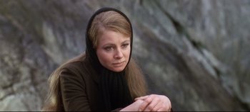 Movie still from “Ryan's Daughter” (1970), directed by David Lean – A woman wearing a head scarf sitting in front of a rock wall; Close Up shot, Low angle