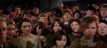 Movie still from “Ryan's Daughter” (1970), directed by David Lean – A large group of young people in a room; Medium shot, High angle