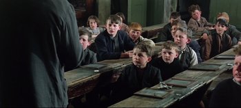 Movie still from “Ryan's Daughter” (1970), directed by David Lean – A group of children sitting at a table in front of a teacher; Medium shot, High angle