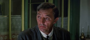 Movie still from “Ryan's Daughter” (1970), directed by David Lean – A person wearing a suit and tie; Close Up shot, Over the shoulder angle