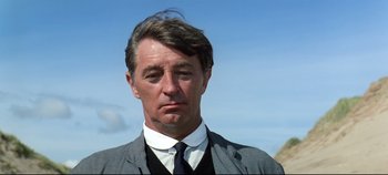 Movie still from “Ryan's Daughter” (1970), directed by David Lean – A person wearing a suit and tie; Close Up shot, Low angle