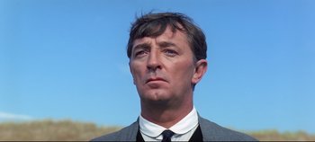 Movie still from “Ryan's Daughter” (1970), directed by David Lean – A person wearing a suit and tie; Close Up shot, Low angle