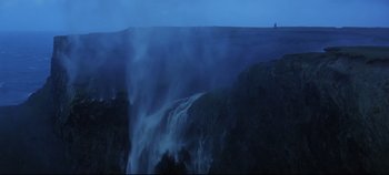 Movie still from “Ryan's Daughter” (1970), directed by David Lean – A man standing on top of a cliff next to a waterfall; Extreme Wide shot, Low angle