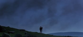 Movie still from “Ryan's Daughter” (1970), directed by David Lean – Two people standing on top of a hill under a cloudy sky; Extreme Wide shot, Low angle