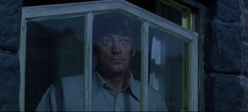 Movie still from “Ryan's Daughter” (1970), directed by David Lean – A man standing behind a window looking at the camera; Close Up shot, Low angle