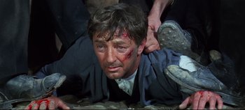 Movie still from “Ryan's Daughter” (1970), directed by David Lean – A person laying on the ground with blood on his face; Close Up shot, High angle